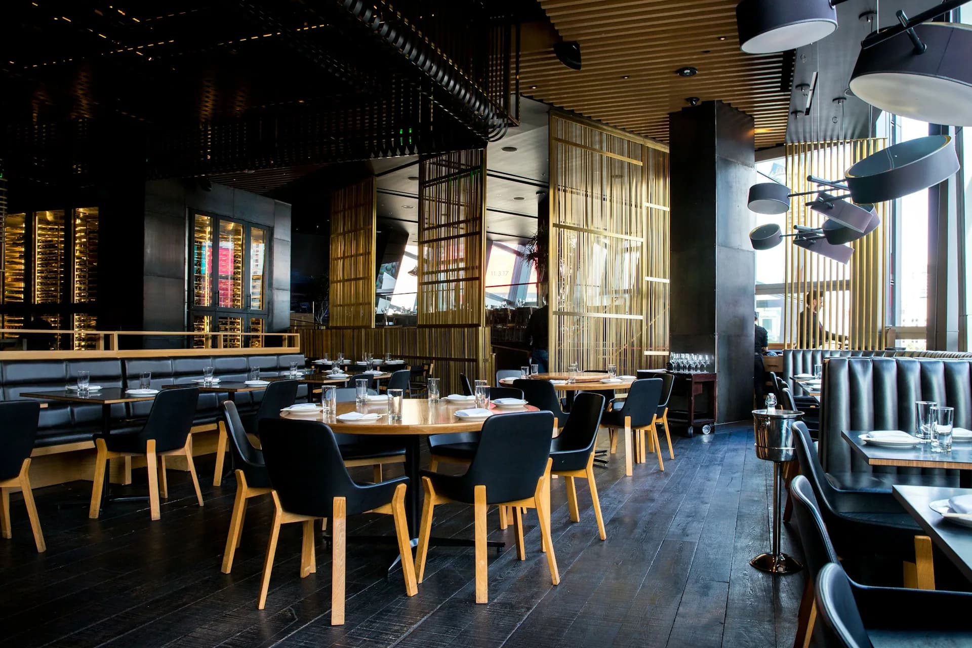 Warm wooden tables and dark chairs beneath pendant lights